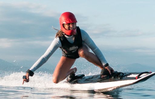 A girl rides on an Awake powered surfboard