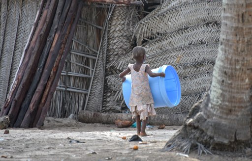 child carries bucket on bwejuu island in tanzania