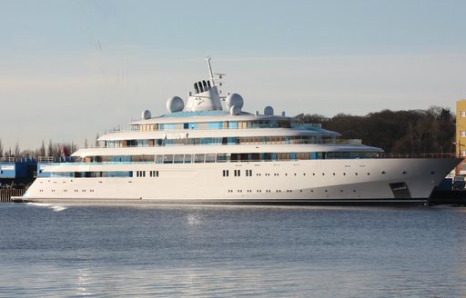 Superyacht GOLDEN ODYSSEY at anchor with a large building aft