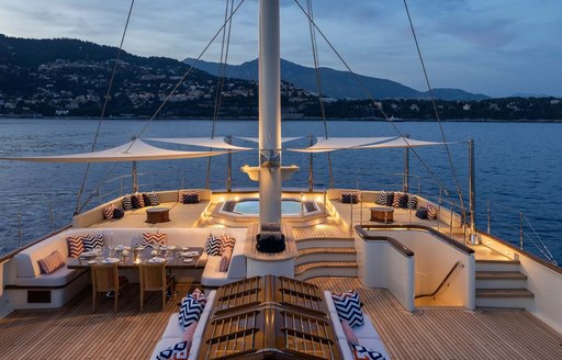 Overview of the main deck onboard charter yacht NERO, with a deck Jacuzzi visible with ample exterior seating and views of the sea 