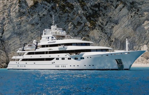 Charter yacht EMIR at anchor by cliffs