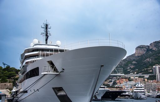 Ground view looking up at the bow of a superyacht berthed in Port Hercule