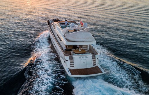 Aft view of charter yacht ESSOESS underway, surrounded by sea at sunset