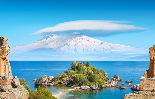 View over Isola Bella and Mount Etna from the ancient Greco-Roman theater in Taormina, Sicily