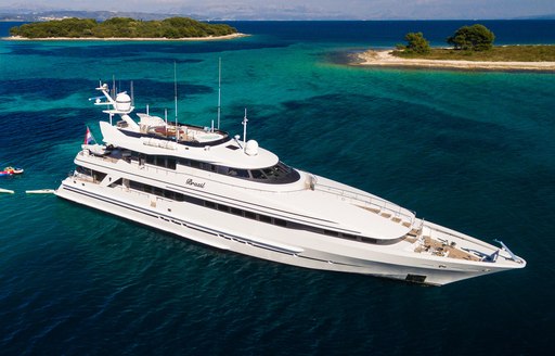 Charter yacht BRAZIL at anchor, with two small islands in the background