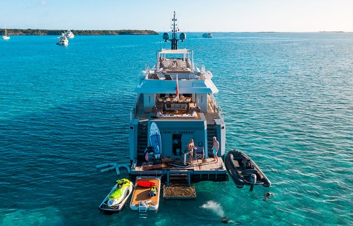 Charter yacht ONLY NOW at anchor with a selection of water toys on the swim platform and adjacent in the water