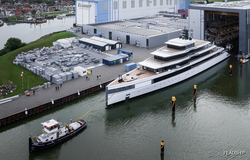 Aerial view of superyacht ULYSSES leaving the Feadship construction shed with tug boat