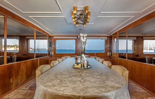 Interior dining area onboard charter yacht SECRET LIFE, long table with windows at the end