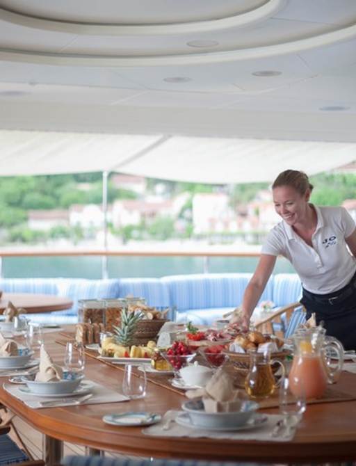 Woman serves meals on superyacht JO