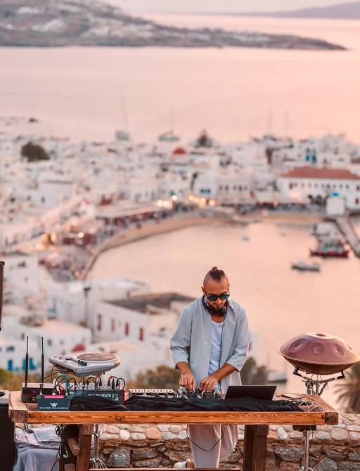 DJ in action at decks by Mykonos harbor