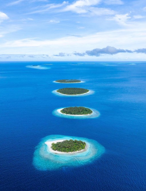 Aerial view looking down on sprinkled islands in the Maldives