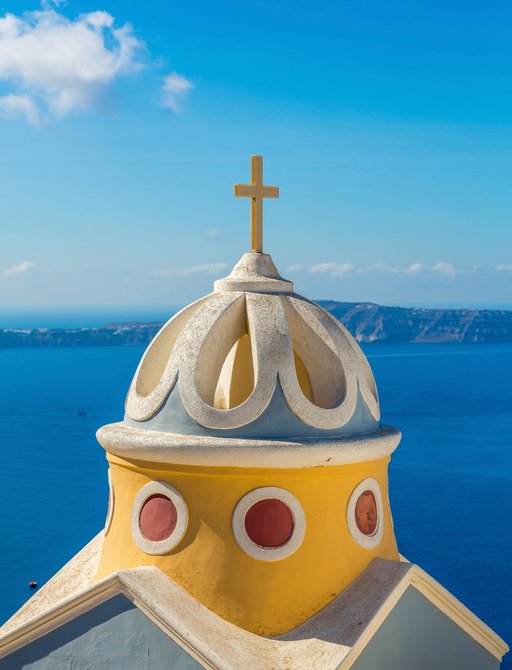 dome on top of Santorini church with views over beautiful blue sea