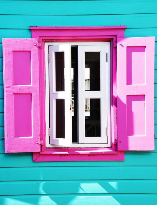 Turquoise house with pink shutters in the Bahamas