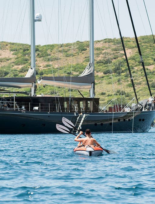 sailing yacht Rox Star at anchor with charter guests on kayaks