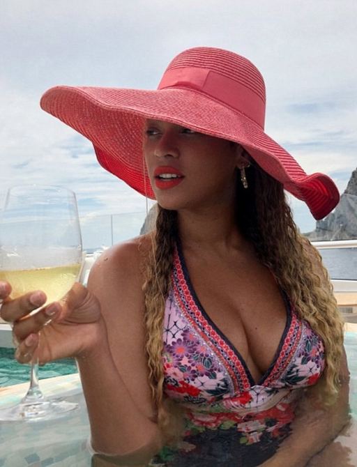 Beyonce in pool with drink and pink hat on board luxury yacht KISMET