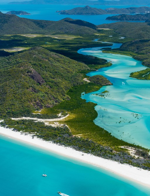 Aerial shot of the Whitsunday islands, blue sea and white sand beach
