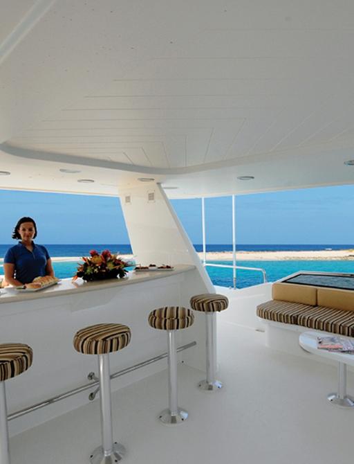 luxury motor yacht ARIOSO outdoor bar on deck with crew member 
