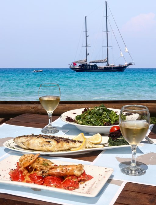 Table with seafood with yacht in the background