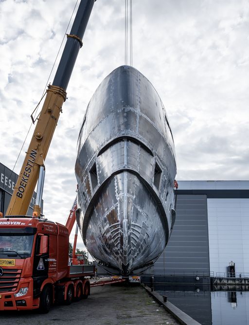 Heesen superyacht Project Orion hovering mid air as she is lifted down of the transportation vehicle.