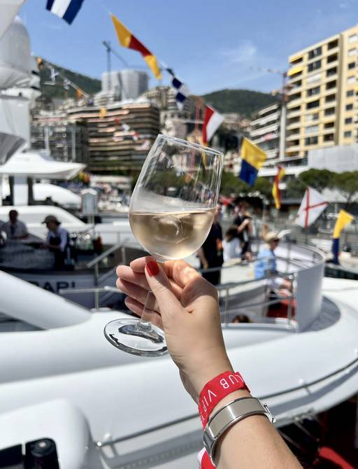 A VIP guest holds up a glass of wine at the Monaco Grand Prix