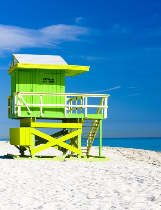 A bright green lifeguard station perched on a beach in the USA