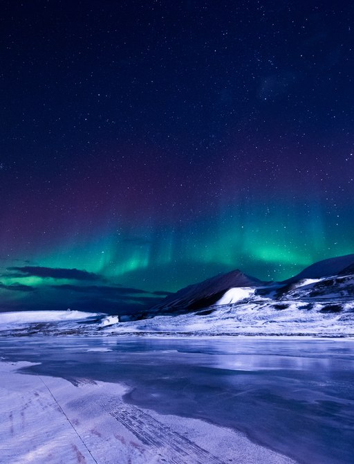 beautiful image of the snowy mountains and Northern Lights in Svalbard