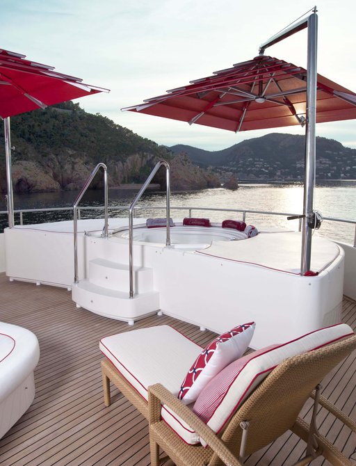 sundeck Jacuzzi with red umbrellas above on board charter yacht EMOTION