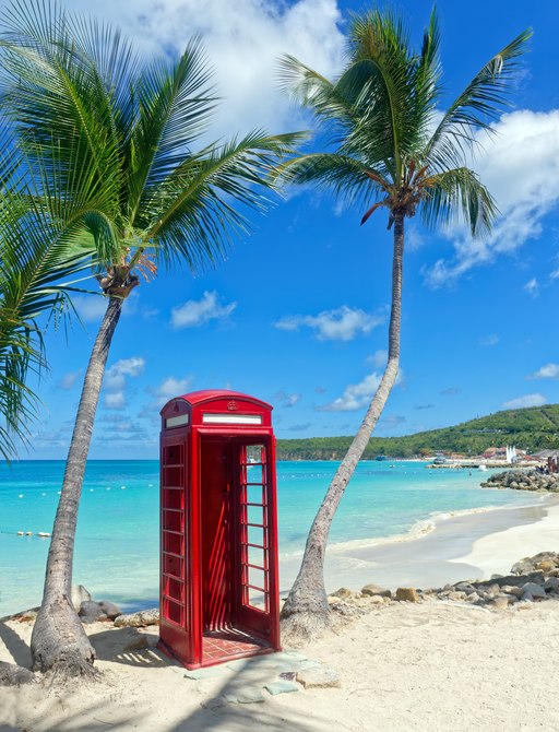 A red British phone box on a beach in the British Virgin Islands