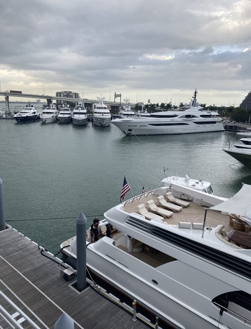 event guests and brokers on the lower aft deck of a luxury superyacht that is part of the 2020 miami yachts how