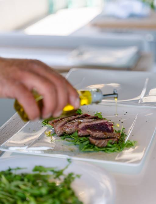 A chef putting the final touches to a meal on board charter yacht ROCCO