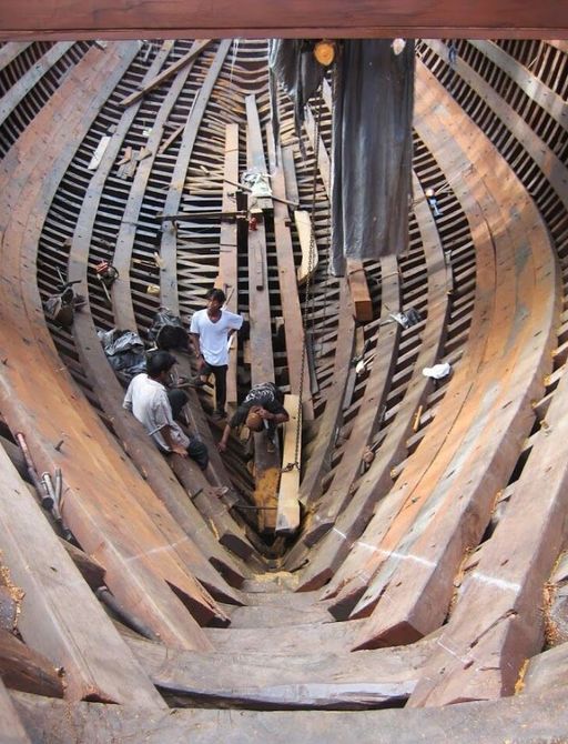 A Konjo boat builder works on the hull of luxury phinsi Dunia Baru
