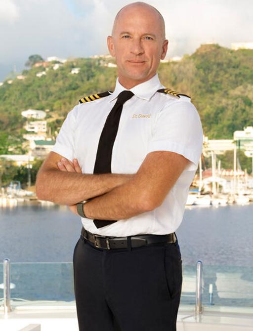 Captain Kerry Titherage of Below Deck Season 11 standing for promotional image for new season 