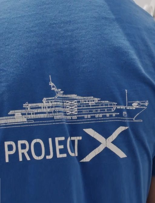 A worker wears a Project X 'T' shirt at the launch of motor yacht Project X from the Greek shipyard Golden Yachts