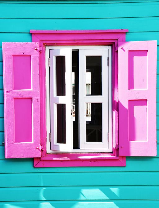 Turquoise house with pink shutters in the Bahamas