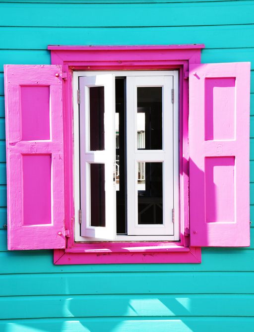 A colorful house with pink shutters in the Caribbean