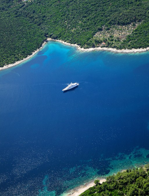 A solitary yacht anchored off a lush island in Croatia