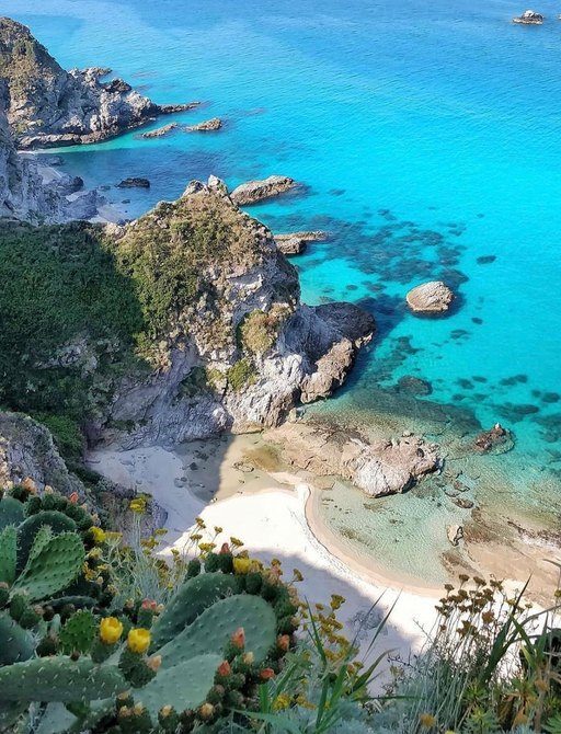 ariel shot of white sands and crystal clear blue waters at Capo Vaticano beach, Calabria