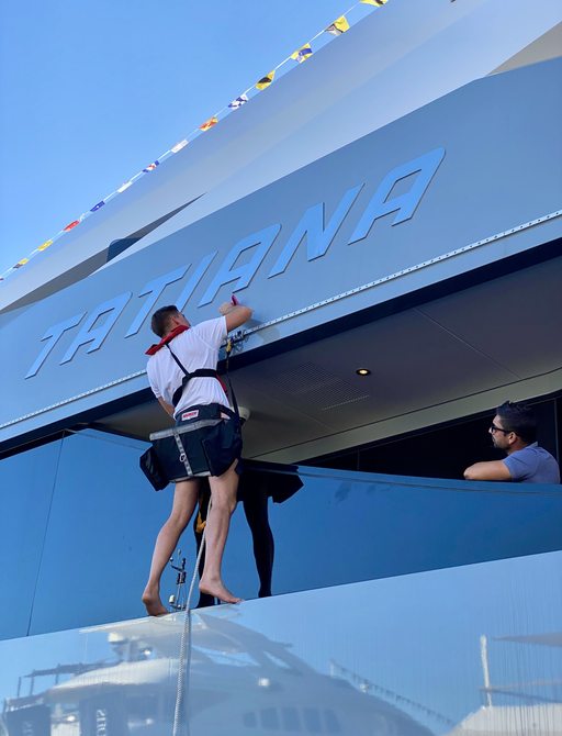 Crew member cleaning charter yacht TATIANA ready for the Monaco Yacht Show 2021