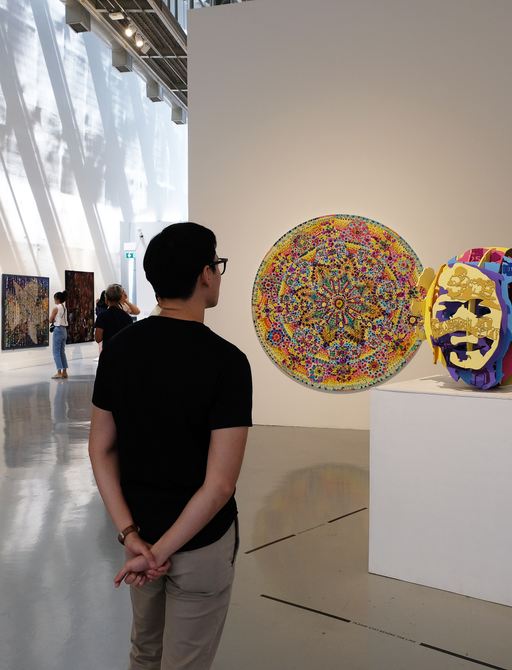 people stroll around one of Art Basel's art exhibits looking at the revelutionary and contemporary art