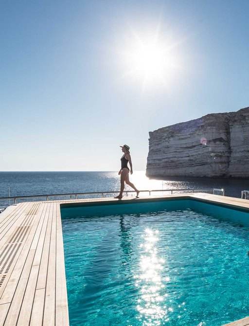woman walking across expansive pool onboard luxury charter yacht LANA