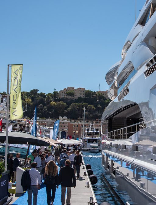 people walking on the blue carpet admiring yachts at the Monaco Yacht Show 2022
