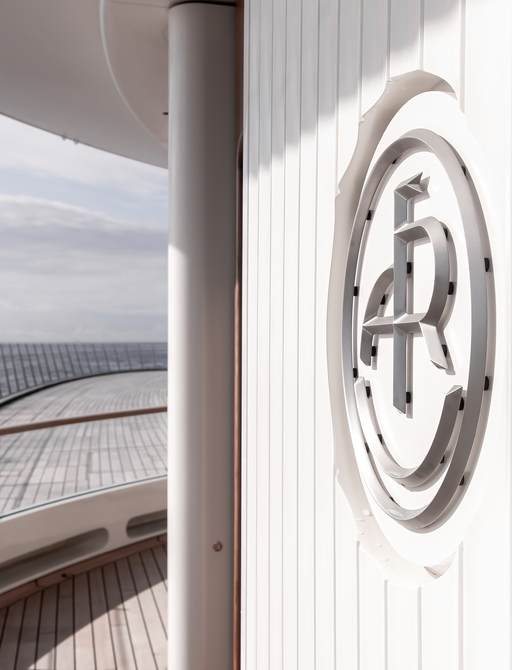 Close up view of an emblem embedded into the superstructure of charter yacht LIVA°. 