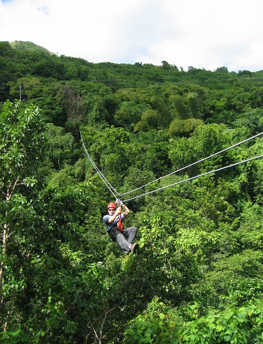 Man soaring above the trees on the Antigua Rainforest Zip Line Tour
