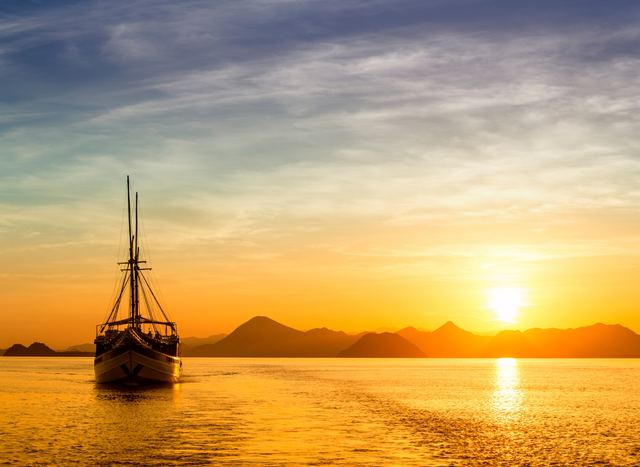 Charter yacht cruising the waters of Komodo as the sun sets
